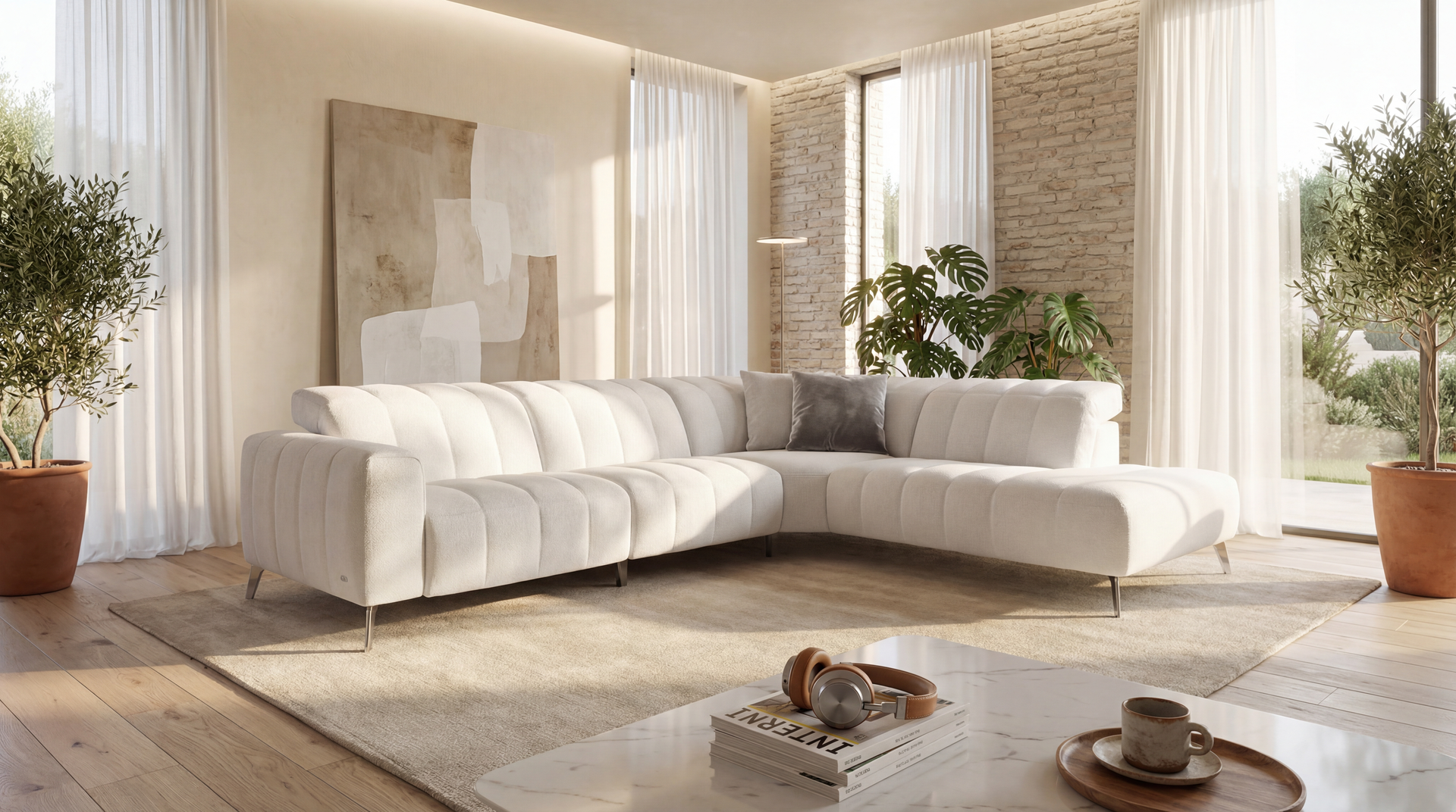 Cream-colored sectional sofa in a sunlit living room with plants, sheer curtains, and a neutral rug.