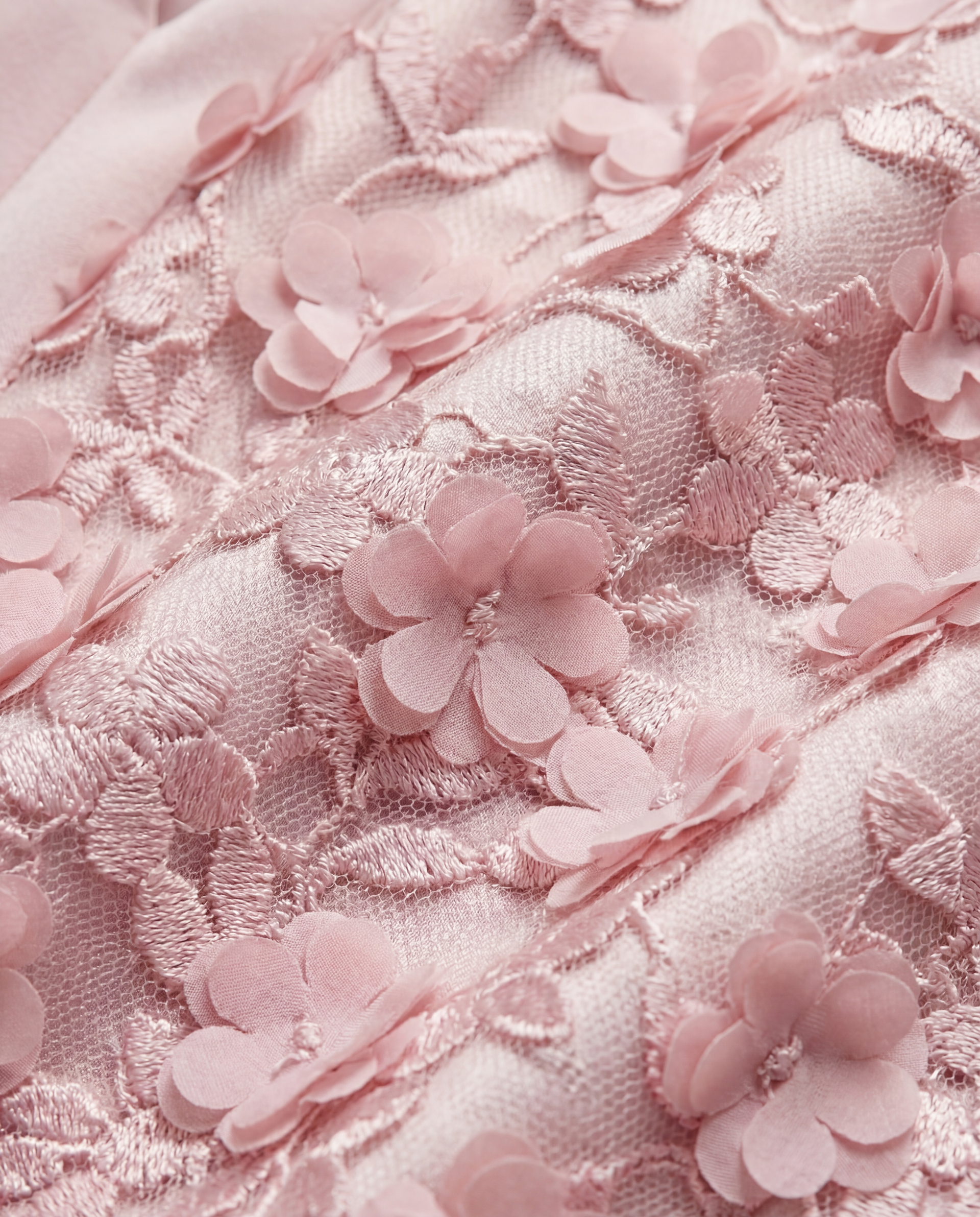 Pink fabric with 3D floral embroidery.