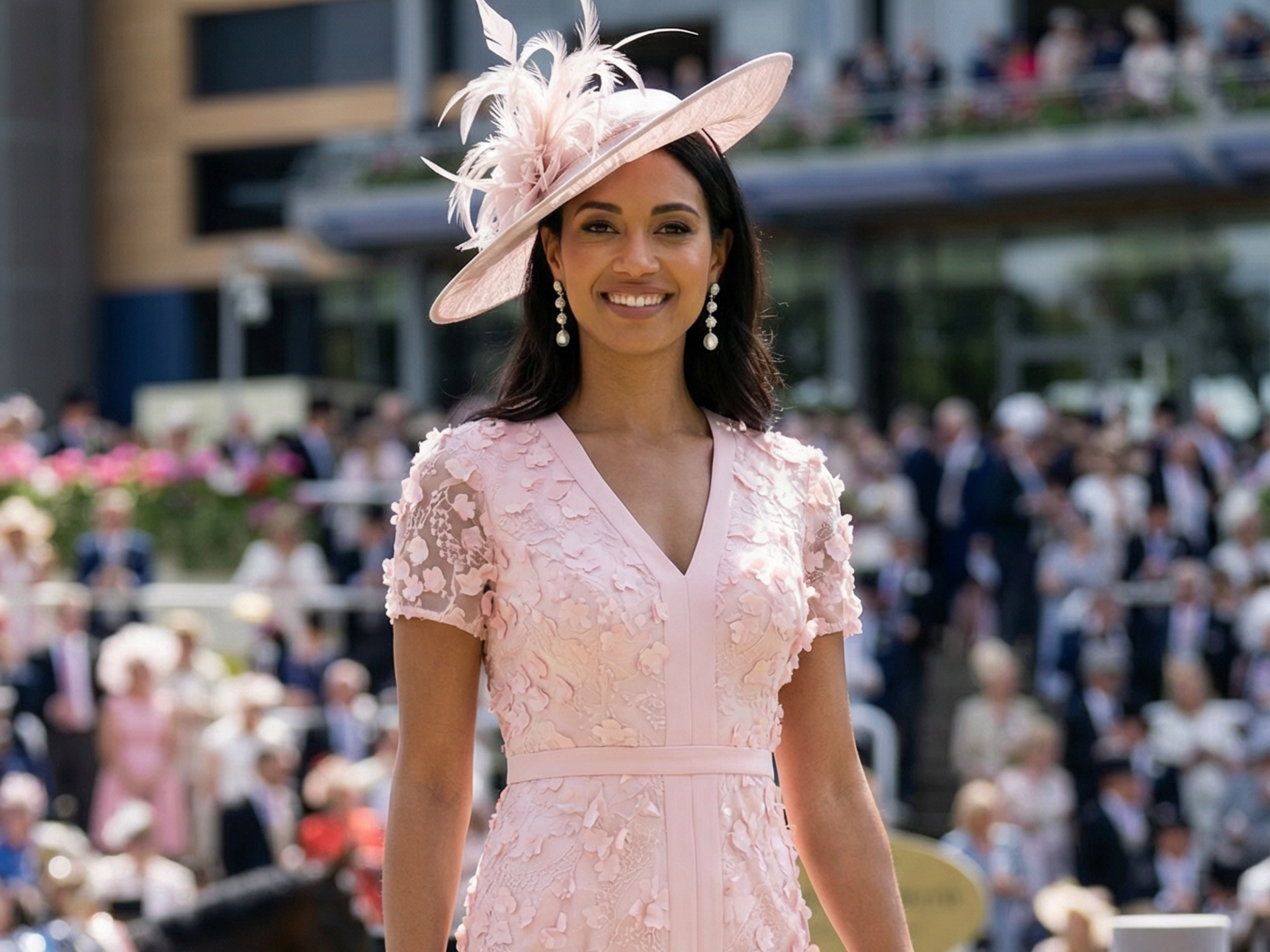 Woman in pink dress and hat at a horse racing event; smiling, outdoors.