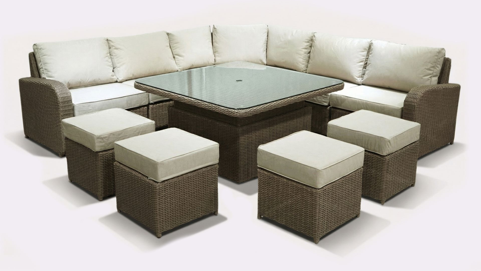 Wicker outdoor sectional sofa with ottomans around a glass-top table, all with beige cushions.