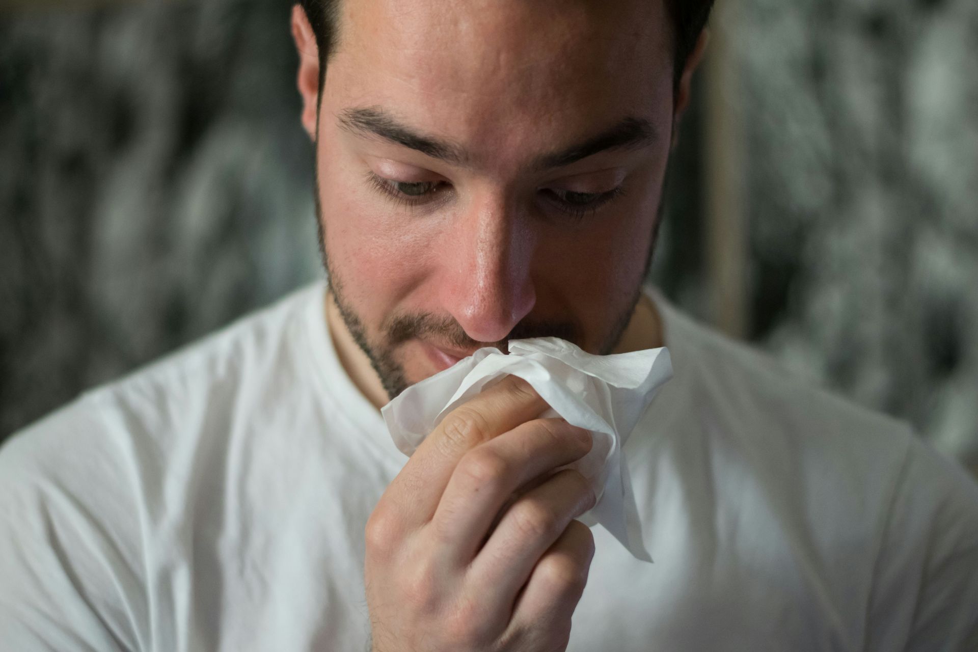 Image shows a person with a tissue in his nose, symbolizing relief from cold and flu symptoms