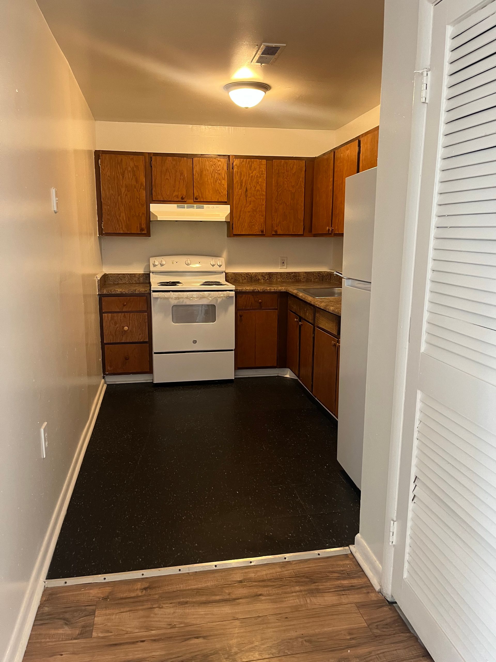 A kitchen with a stove , refrigerator and cabinets