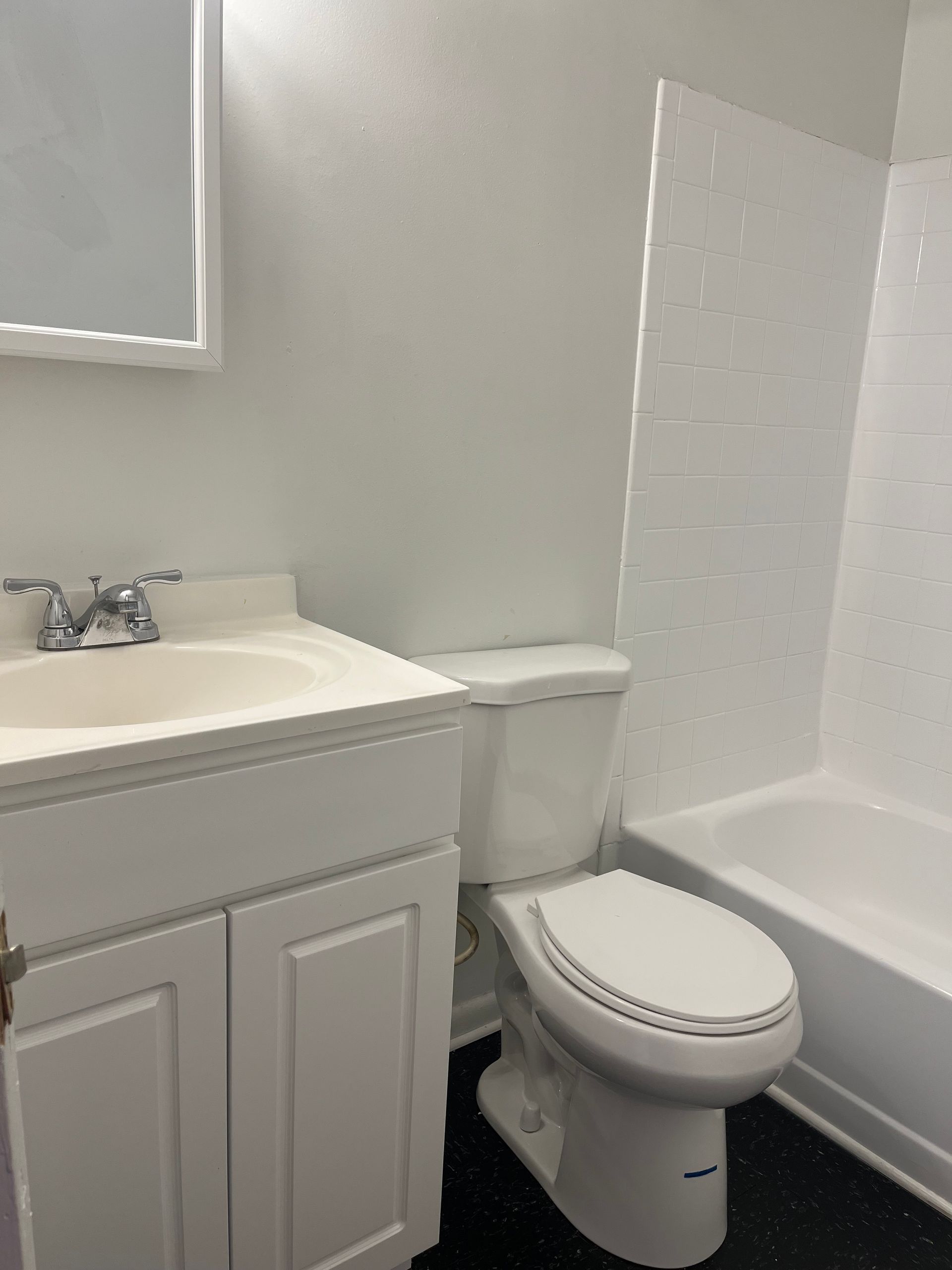 A bathroom with a toilet , sink and bathtub.