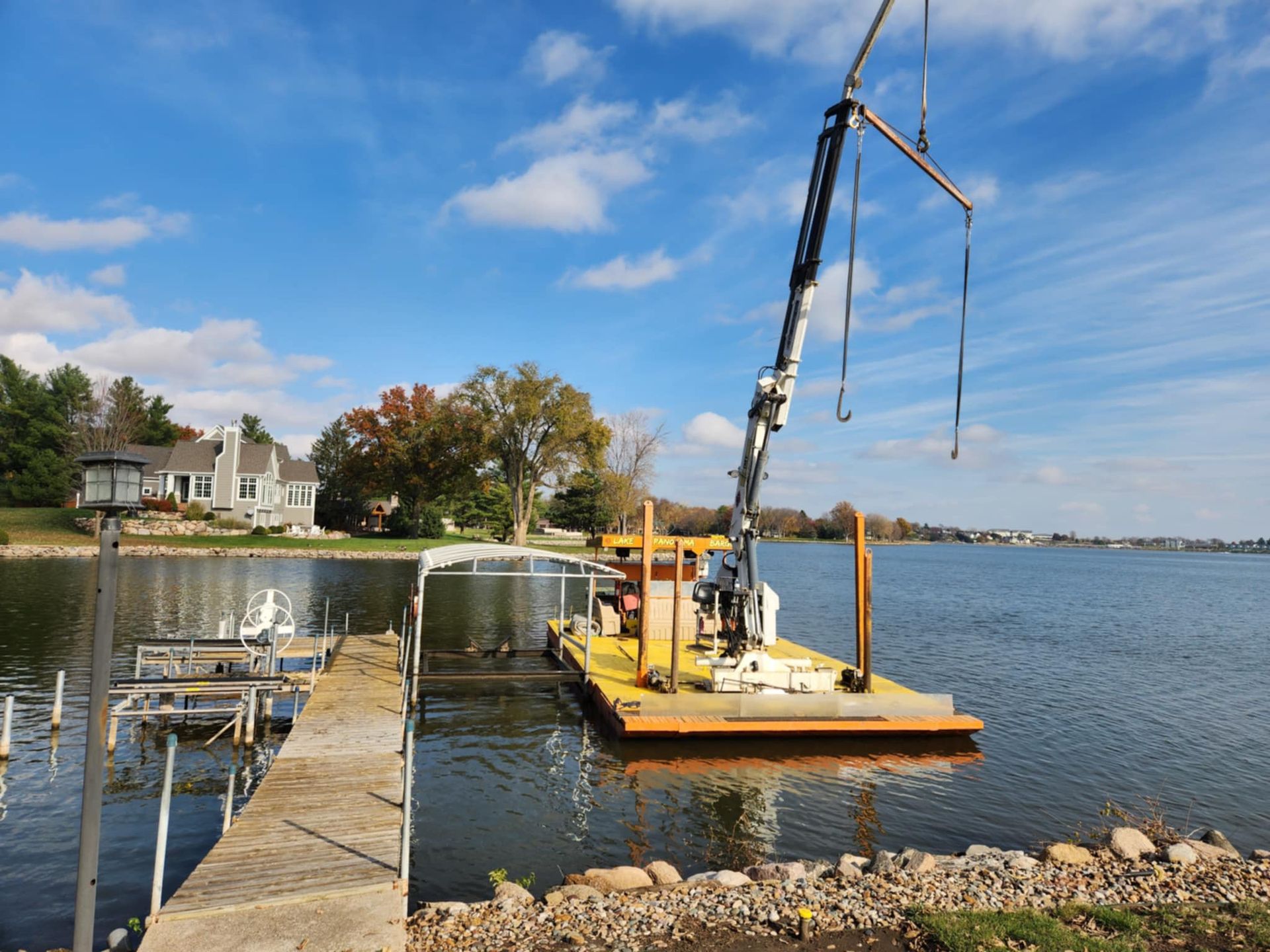 A boat is being lifted into the water by a crane.