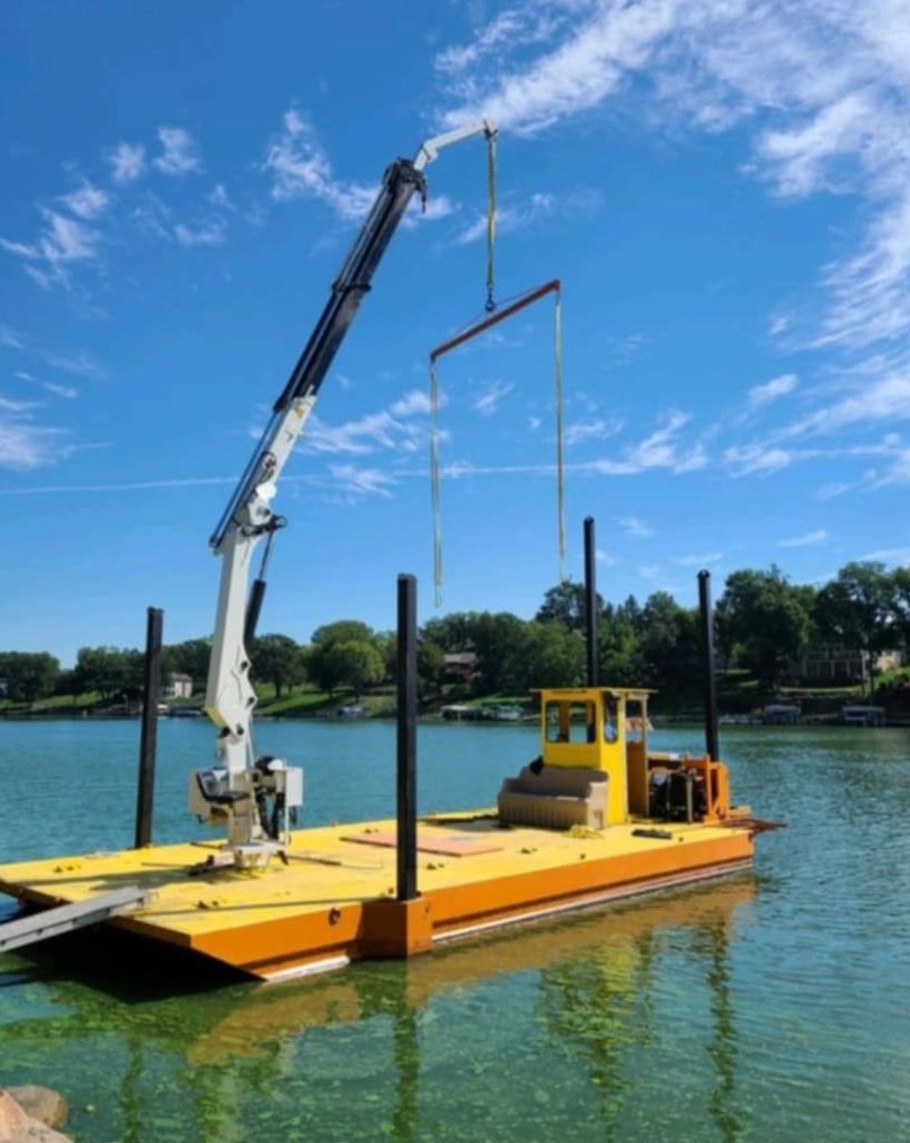 A boat with a crane attached to it is in the water
