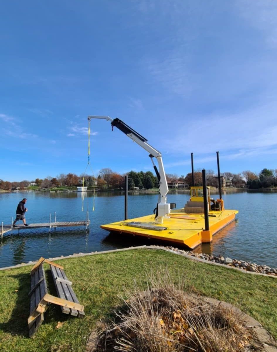 A man is walking on a dock next to a body of water.
