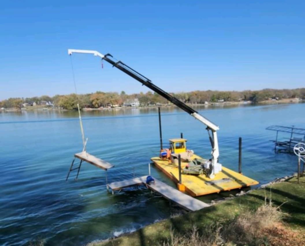 A boat with a crane attached to it is in the water