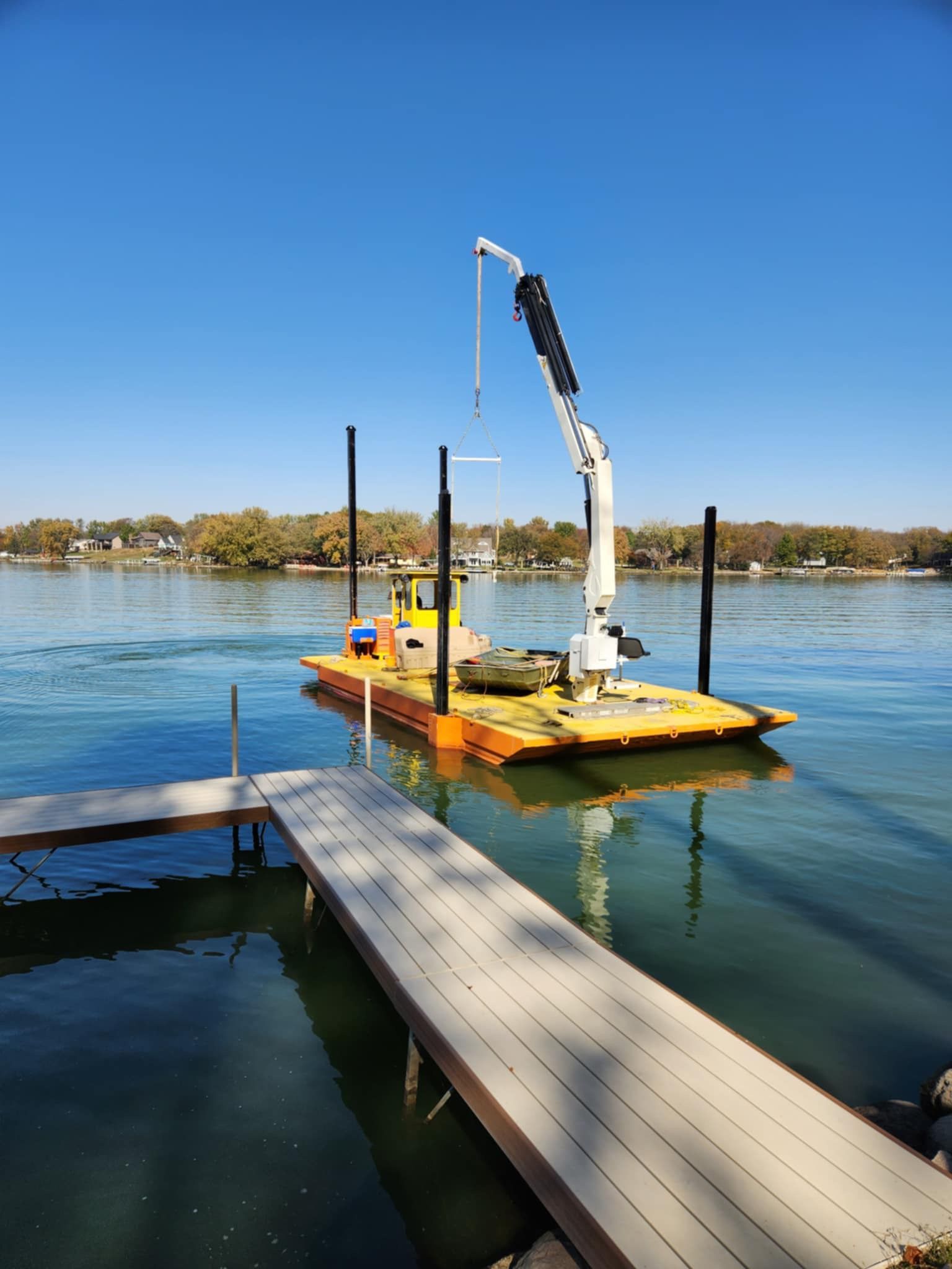 A boat is docked at a dock with a crane attached to it.