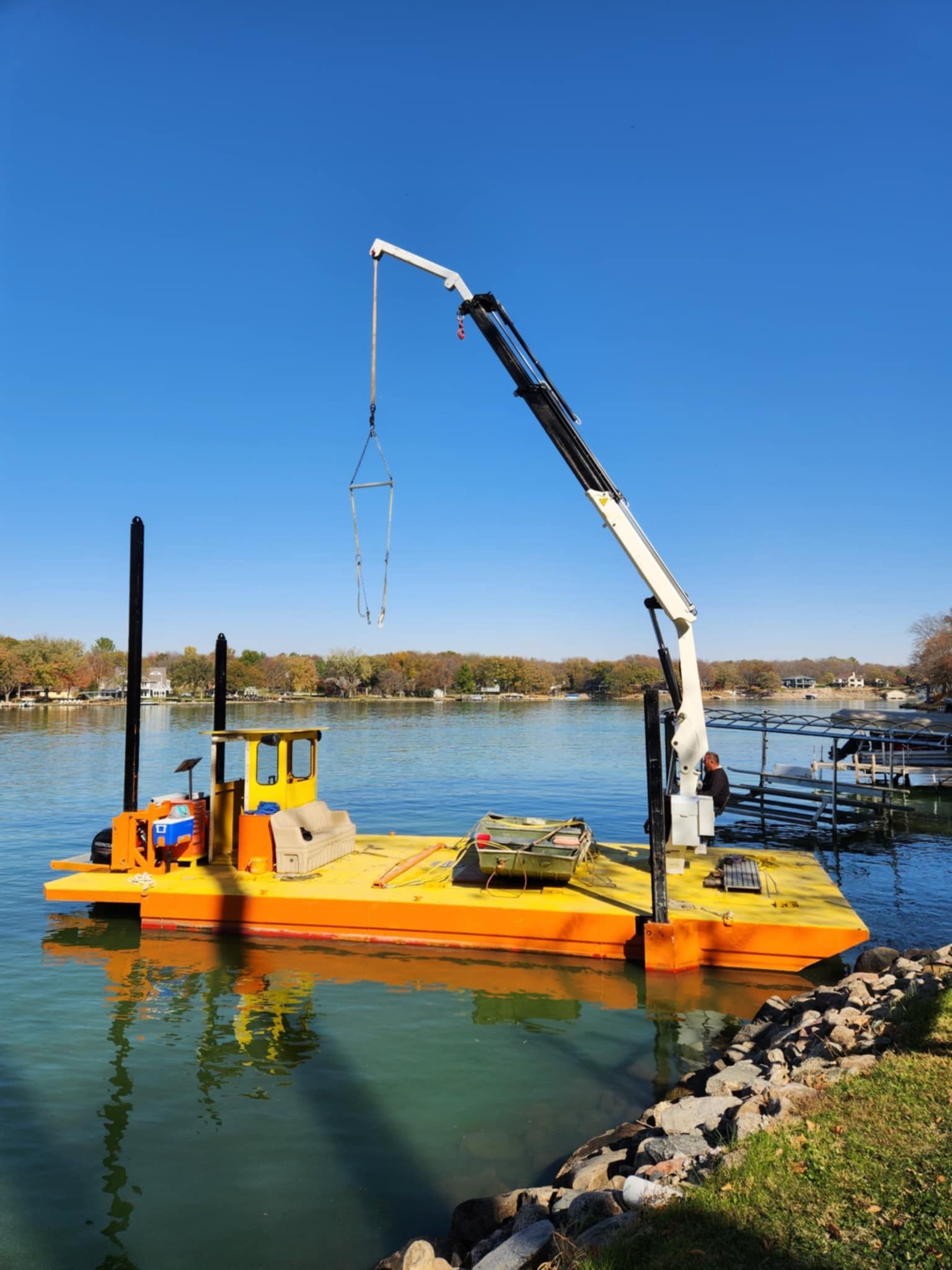 A boat with a crane attached to it is in the water