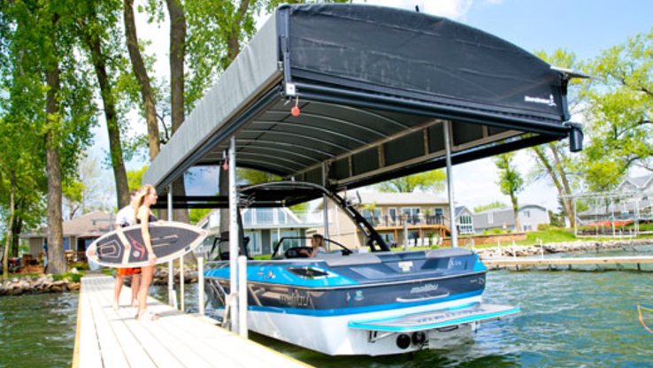 A boat is docked at a dock with a canopy over it.