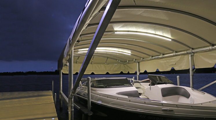 A boat is sitting under a canopy on a dock.