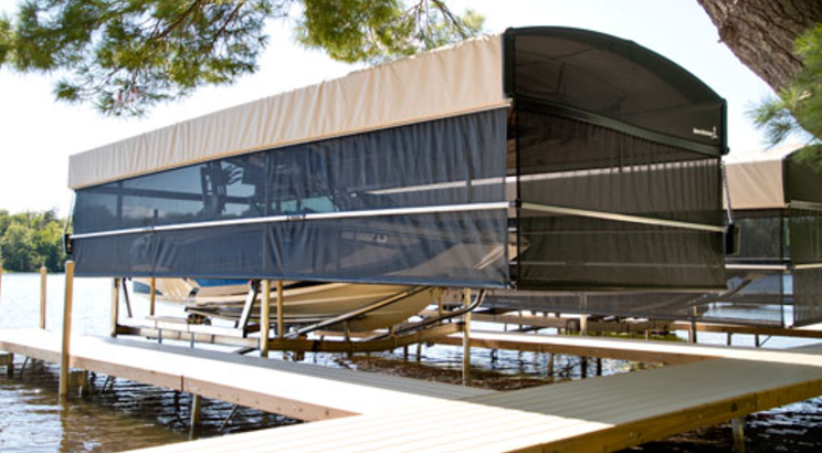 A boat is docked at a dock with a canopy over it.