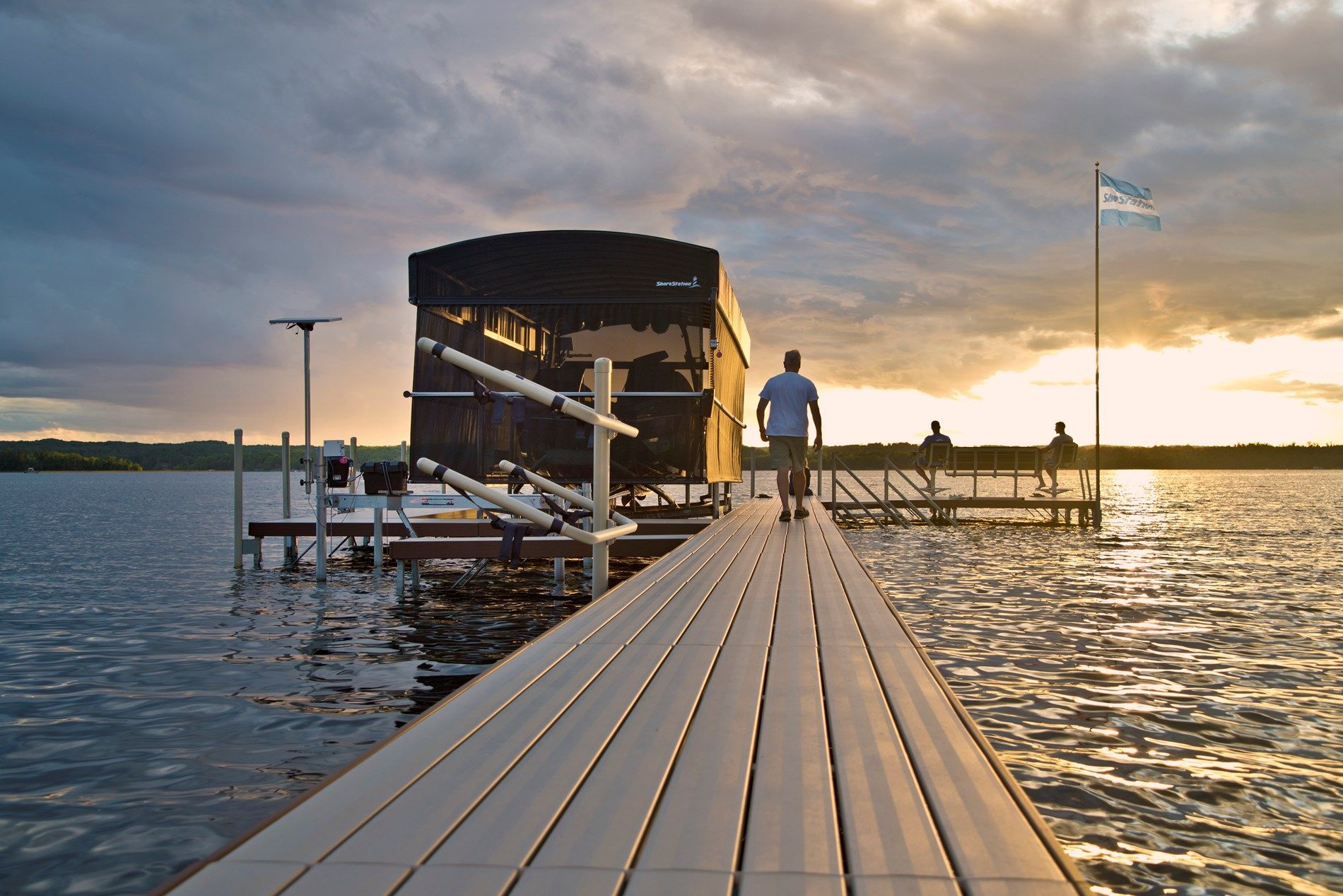 A man is standing on a dock looking at a boat