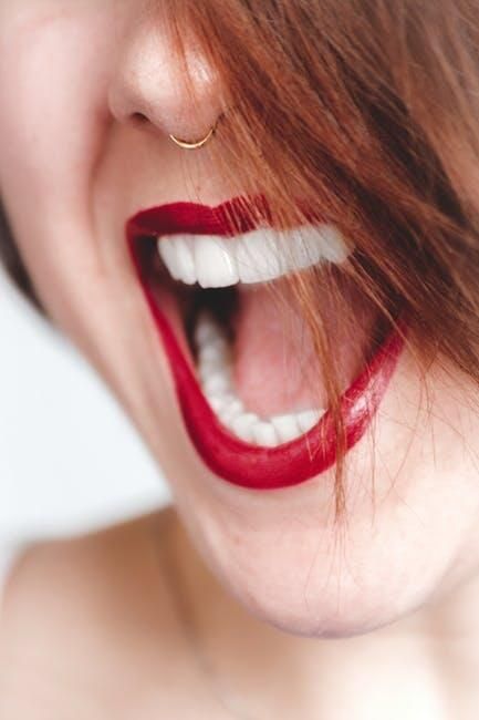 A close up of a woman 's mouth with red lipstick and white teeth.