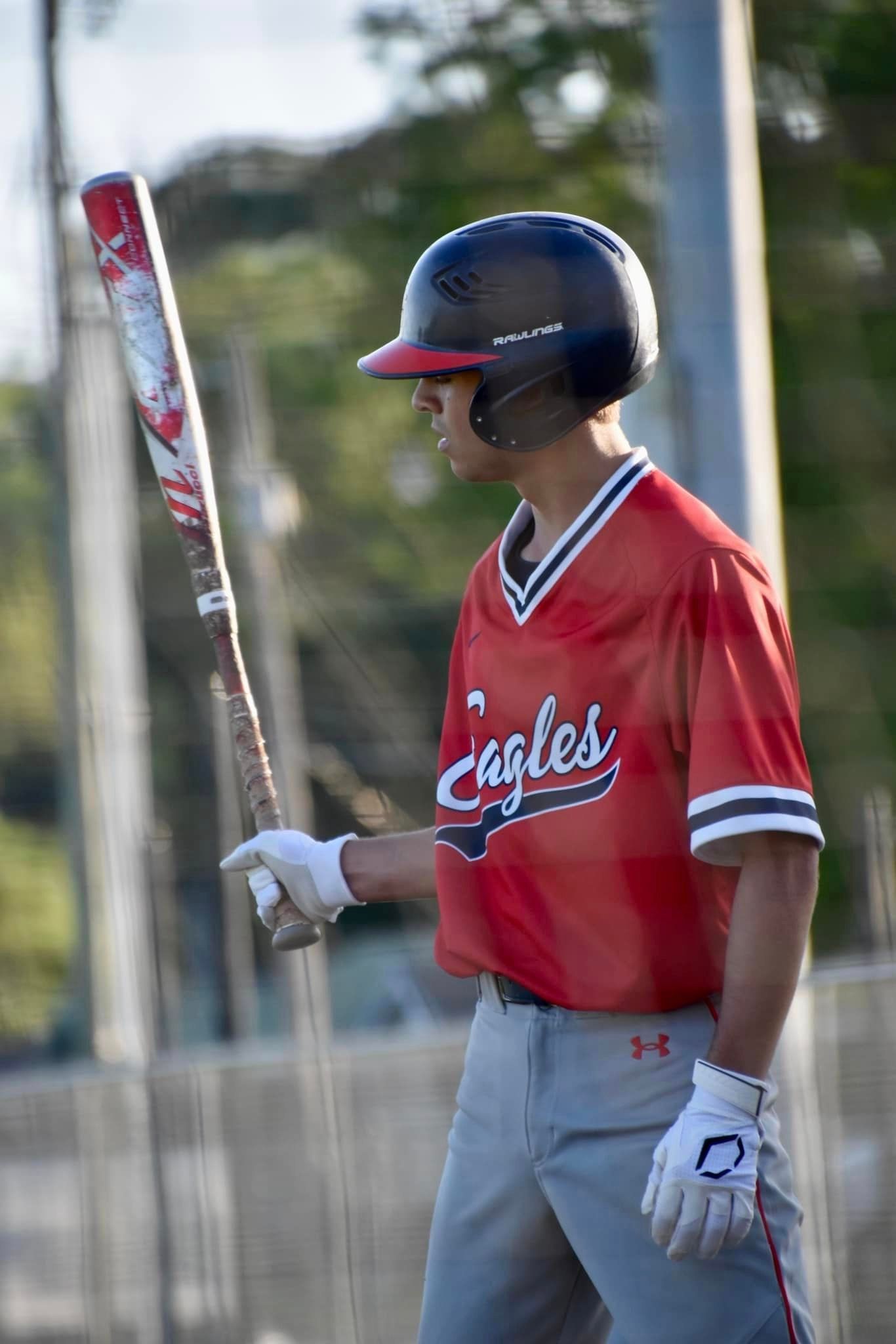 A baseball player for the eagles is holding a bat