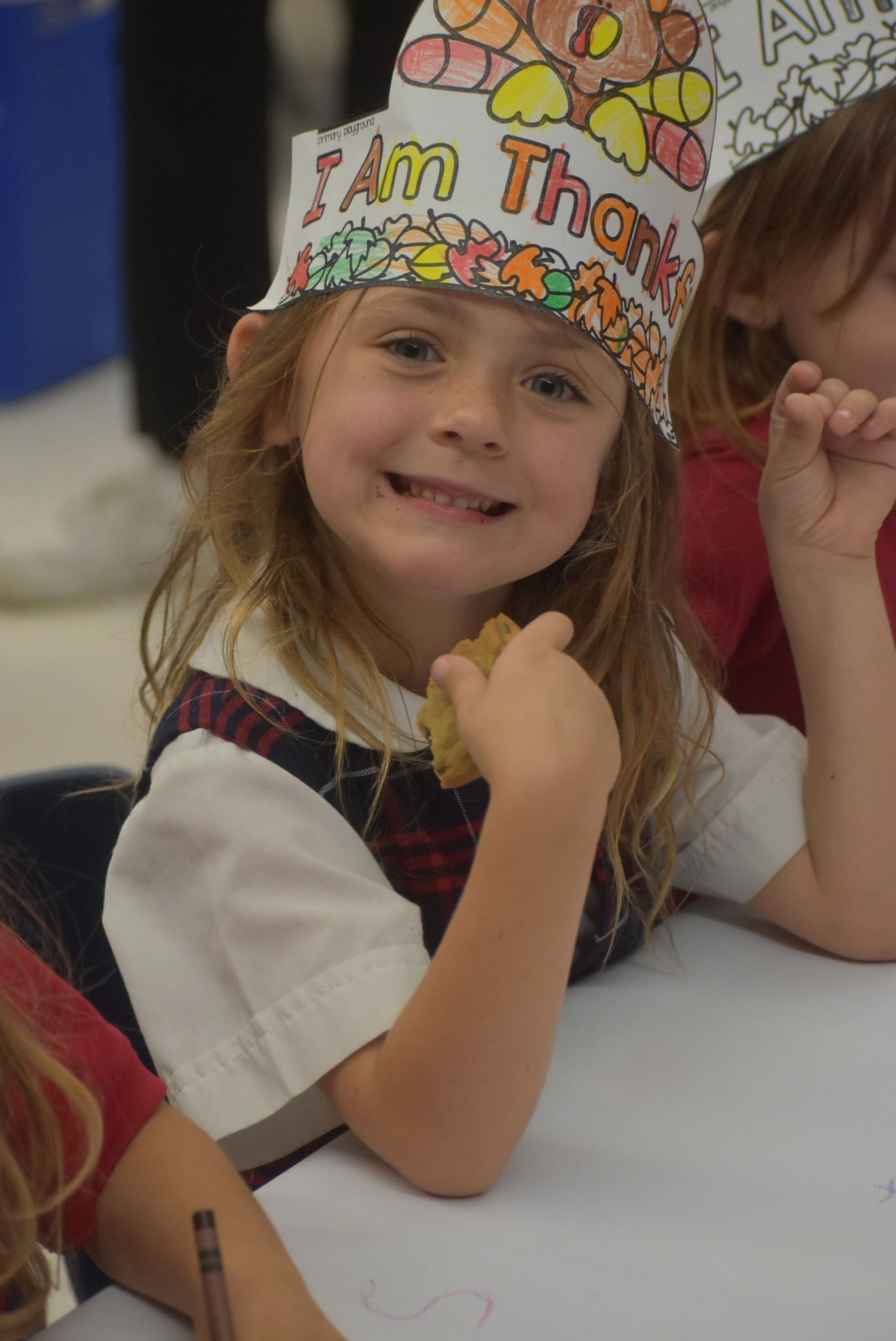 A group of girls are posing for a picture in front of a periodic table board