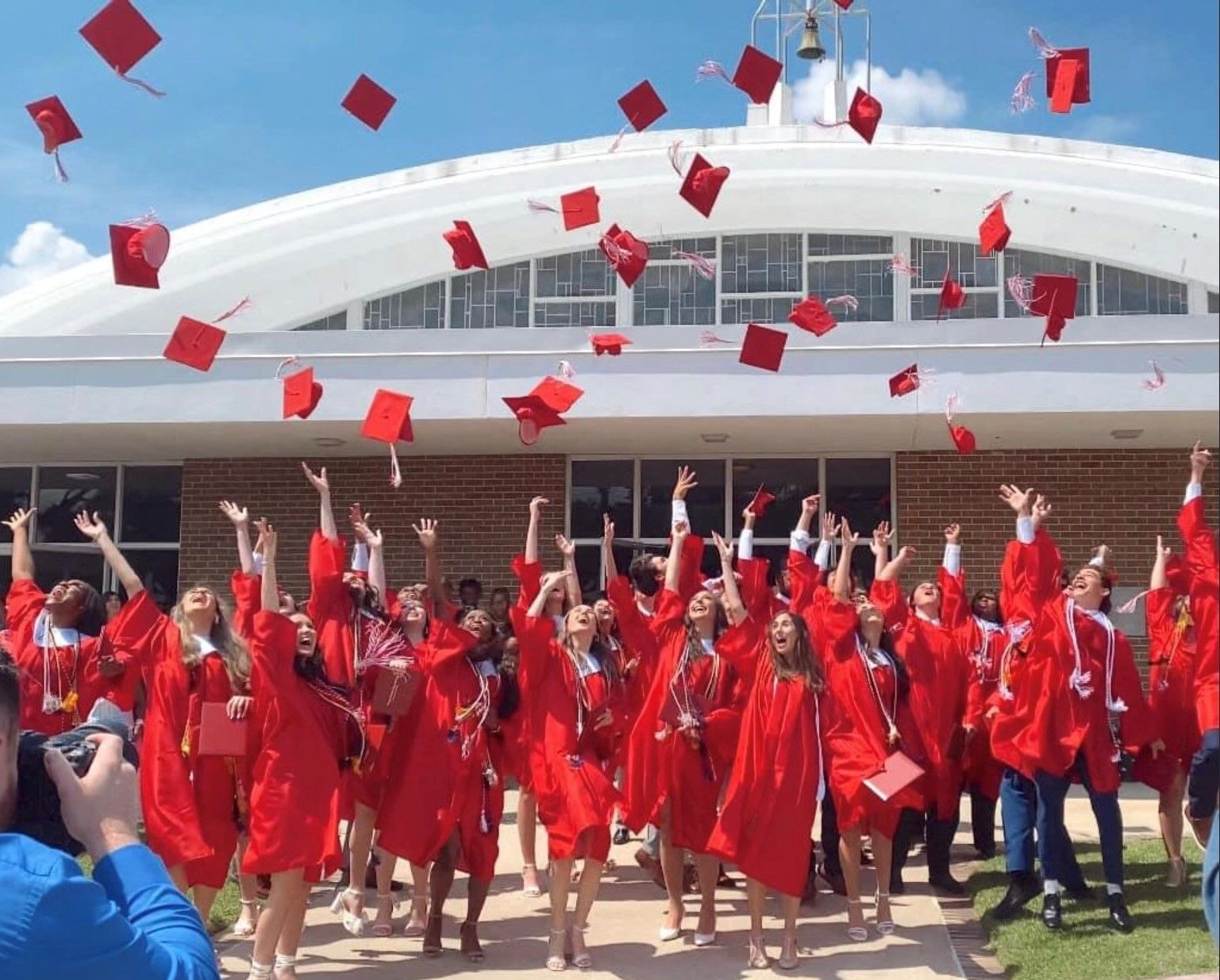 A group of graduates are throwing their caps in the air