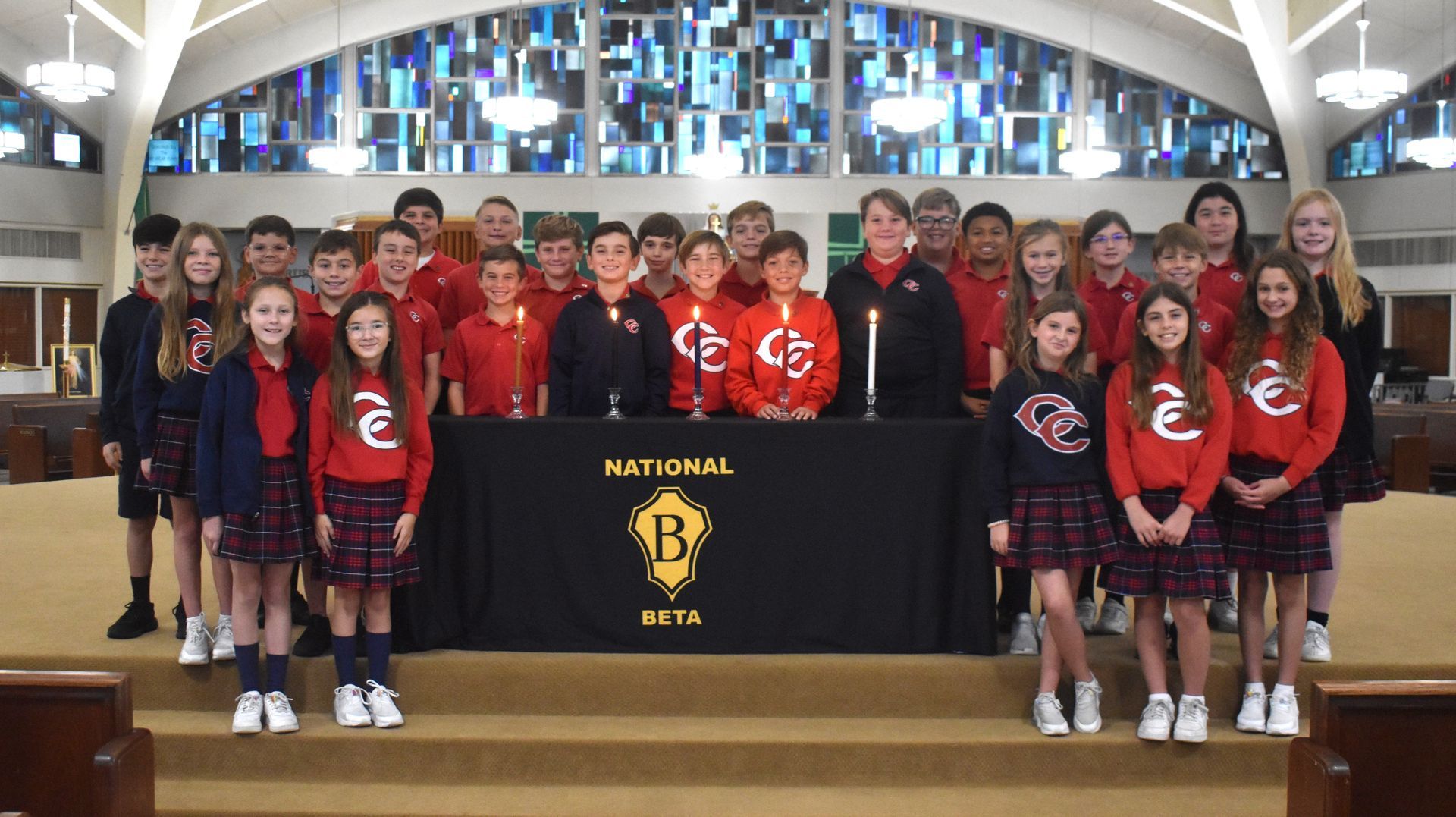 A group of children pose in front of a table that says national