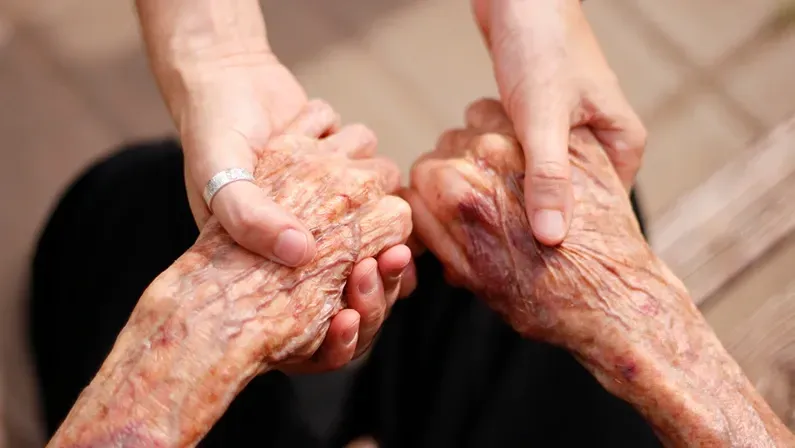 elderly lady and young girl holding hands, support for the elderly