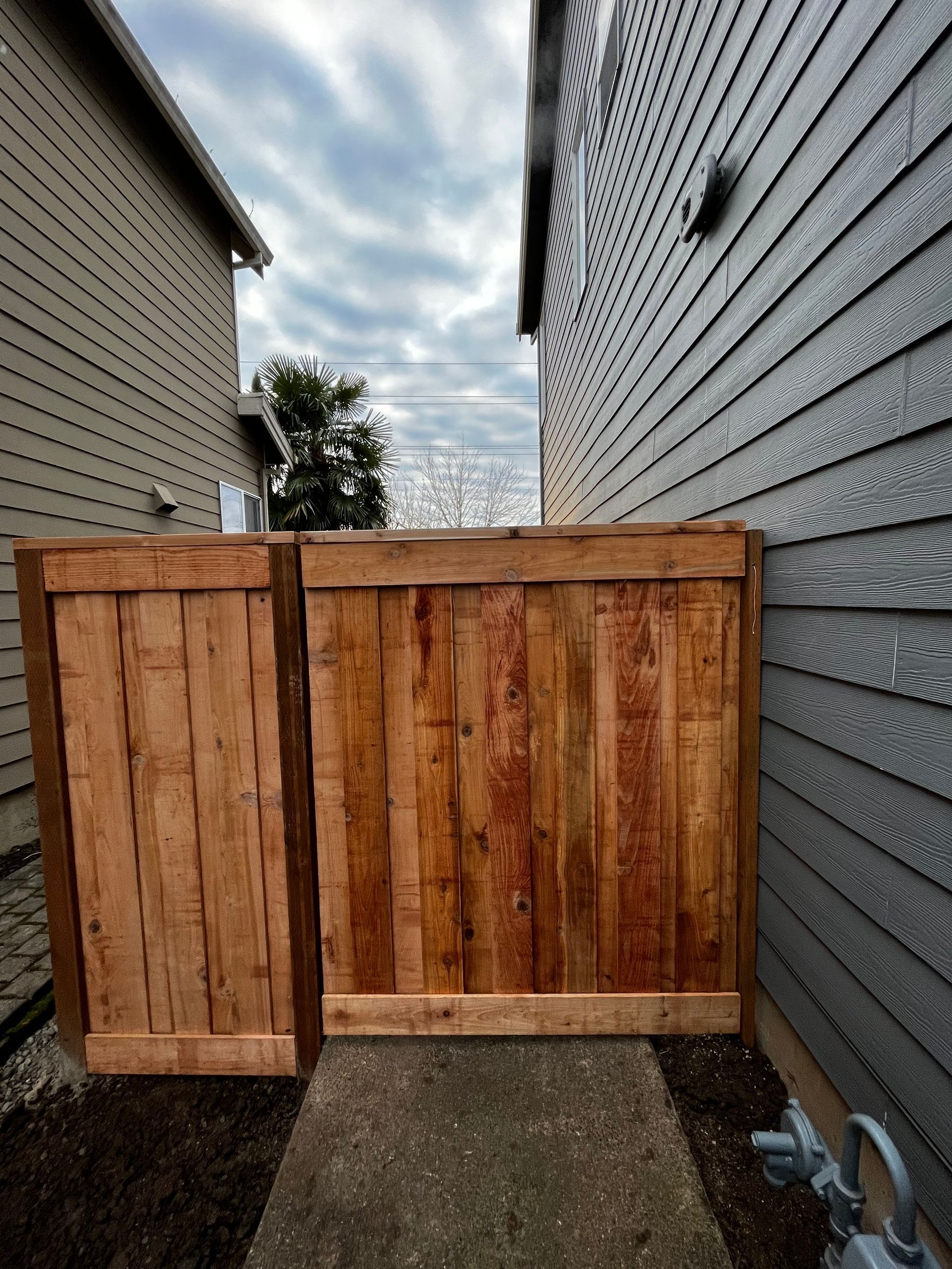 A wooden fence along the side of a house