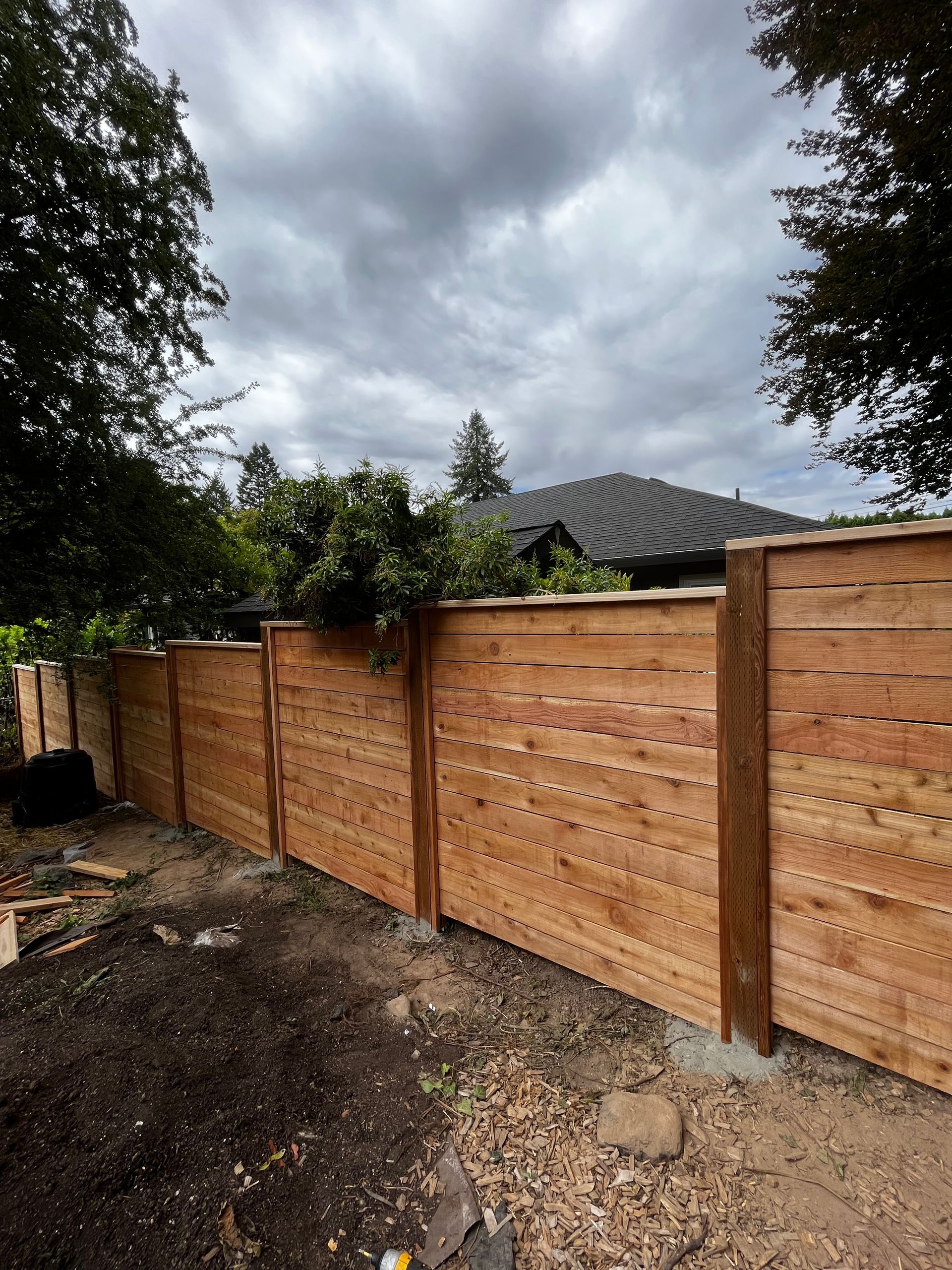 A wooden fence is being built in front of a house.