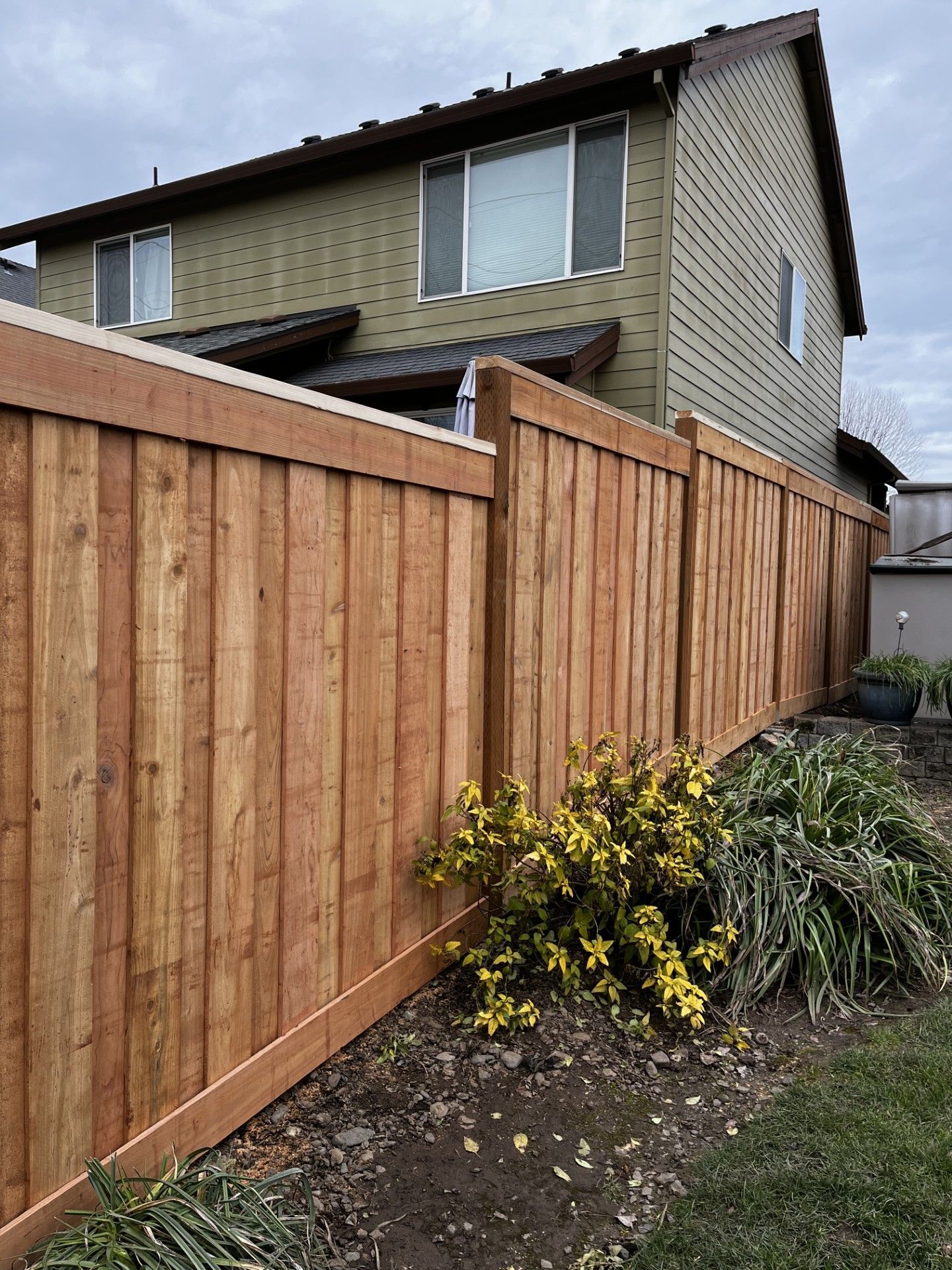 A wooden fence is sitting in front of a house.