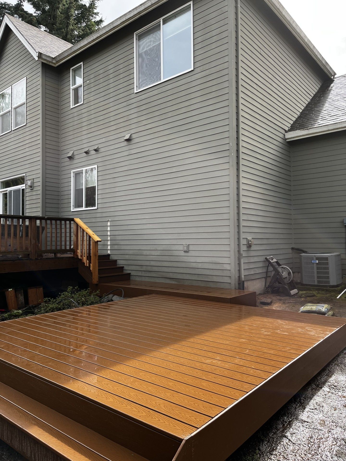 A large house with a wooden deck in front of it.