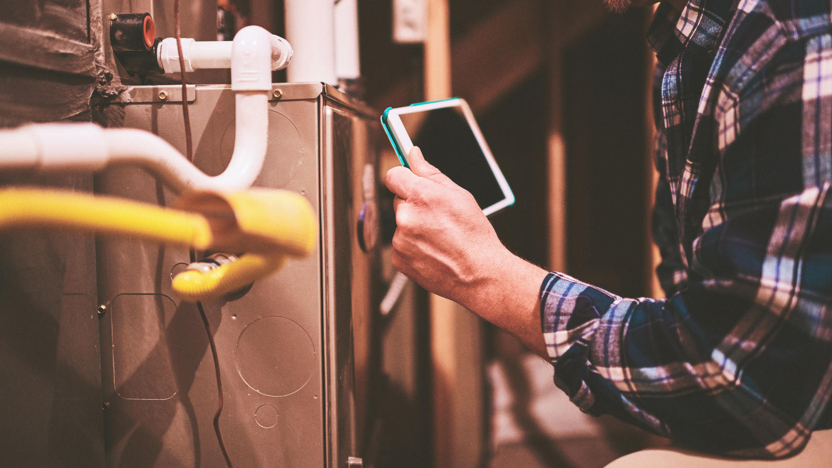 A man is working on an air conditioner outside of a building
