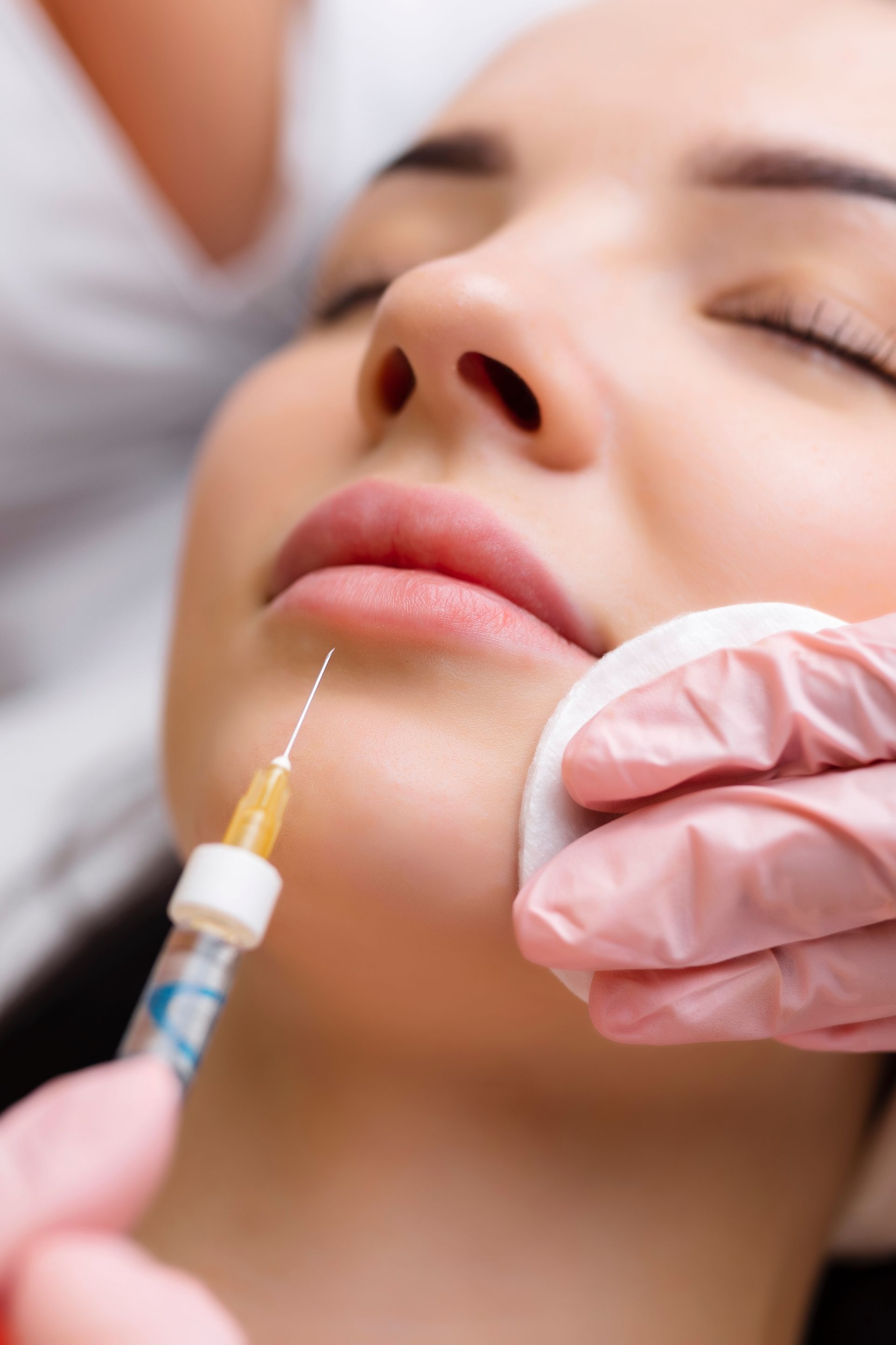 A woman is getting a botox injection in her face.
