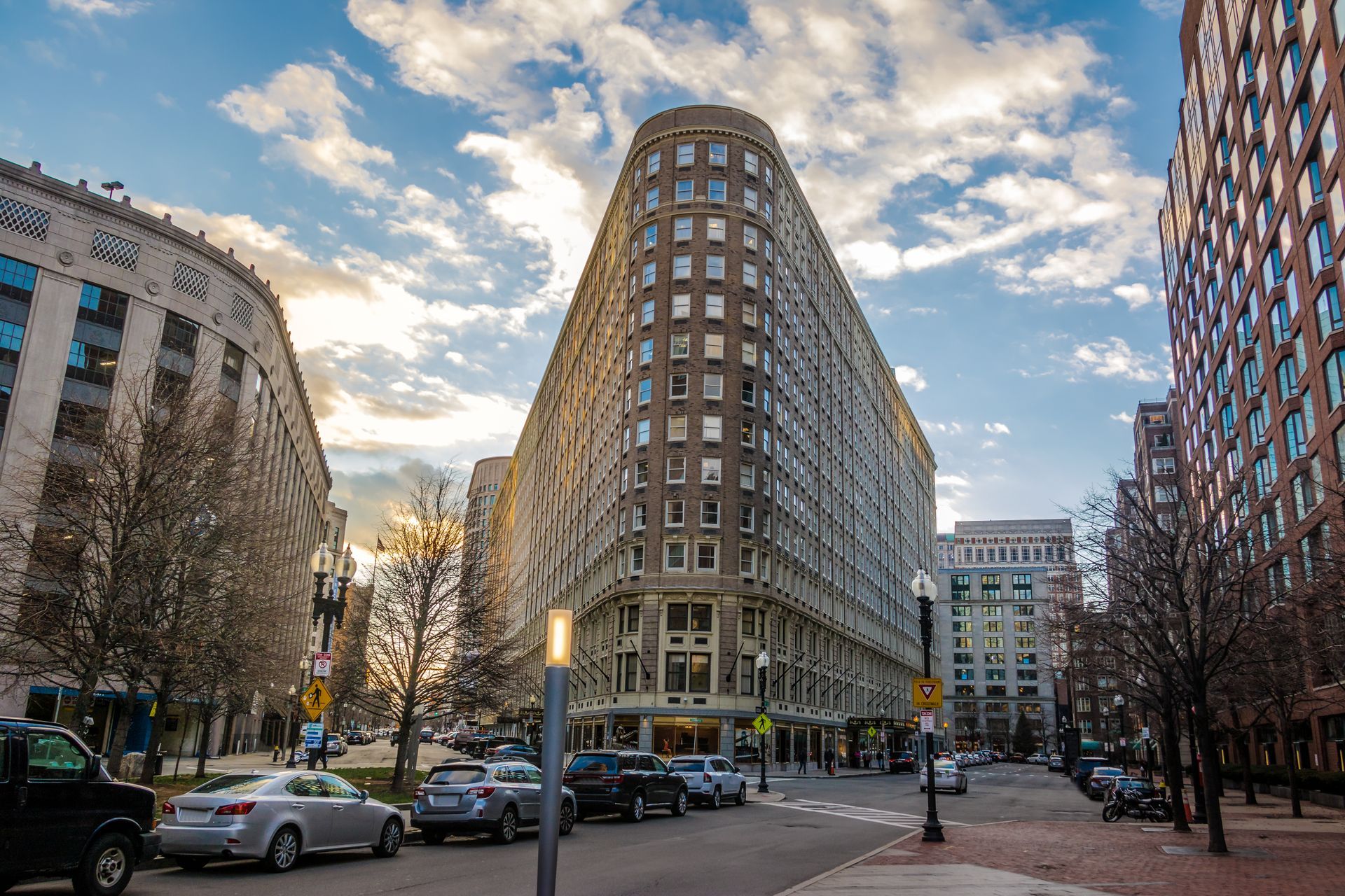 A large building is sitting on the corner of a city street.
