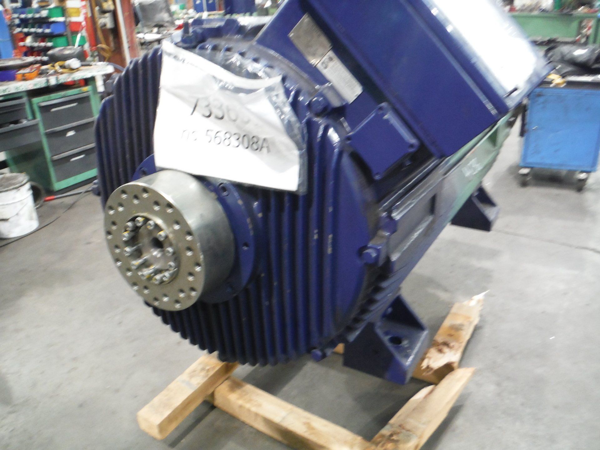 Gran motor industrial de color azul sobre soporte de madera.