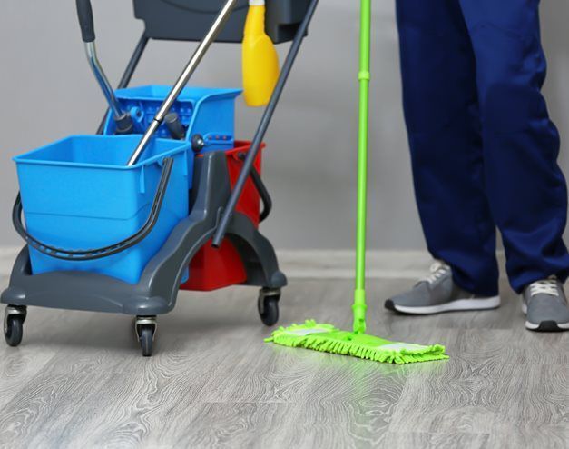 young man cleaning floor green mop