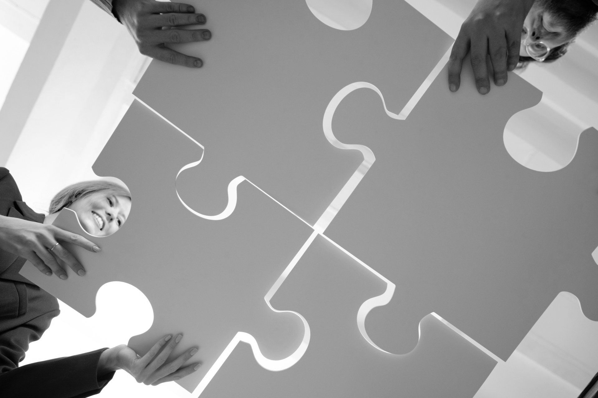 Eine Gruppe von Menschen setzt ein großes Puzzleteil zusammen