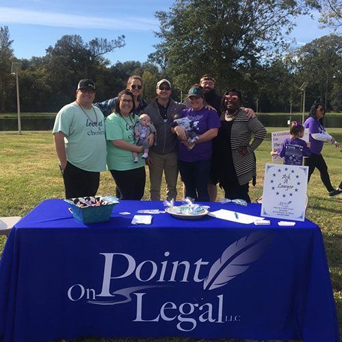 People at an outdoor event with a table displaying a