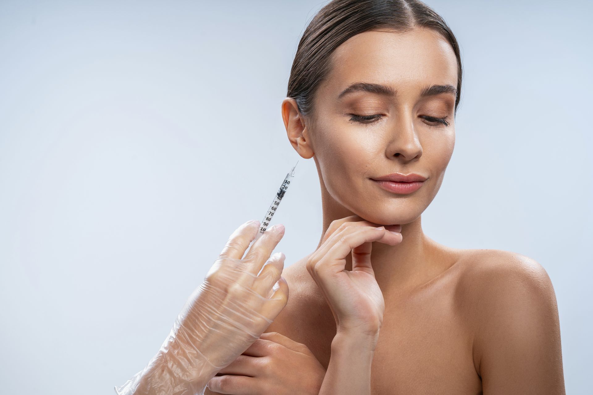 A woman is getting a botox injection in her face.