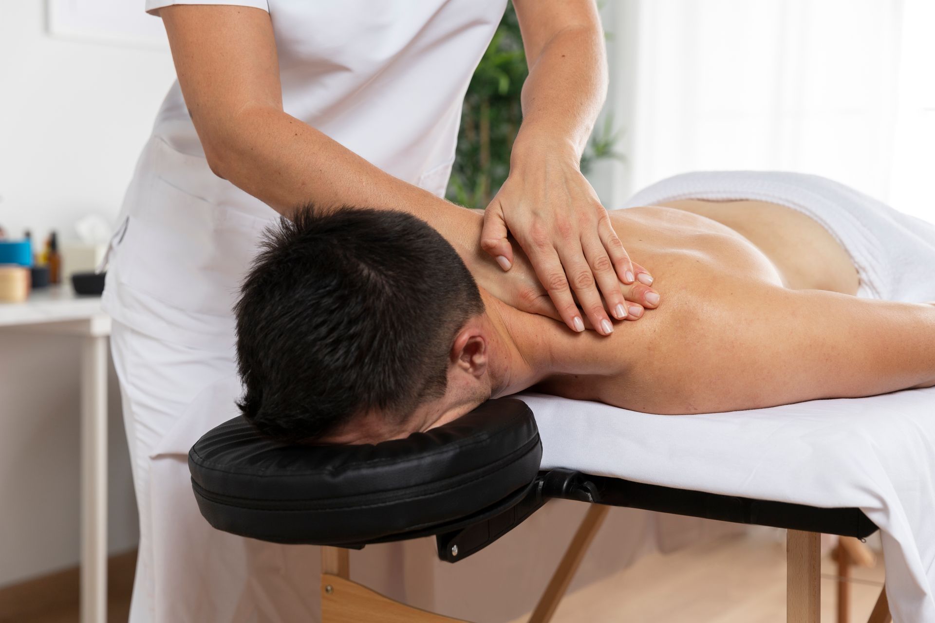 A man is laying on a massage table getting a massage from a woman.