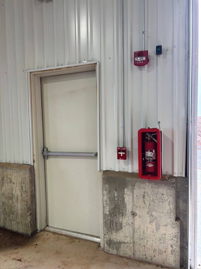 There is a fire extinguisher on the wall next to the door.