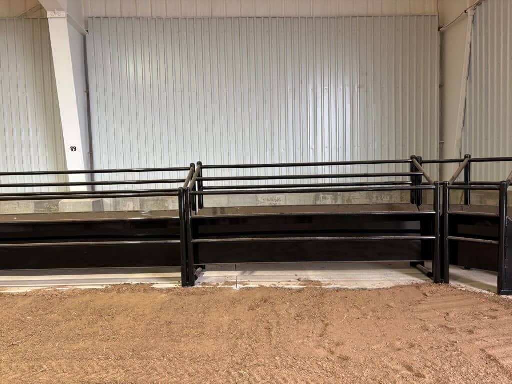 A row of benches in a room with a fence around them.