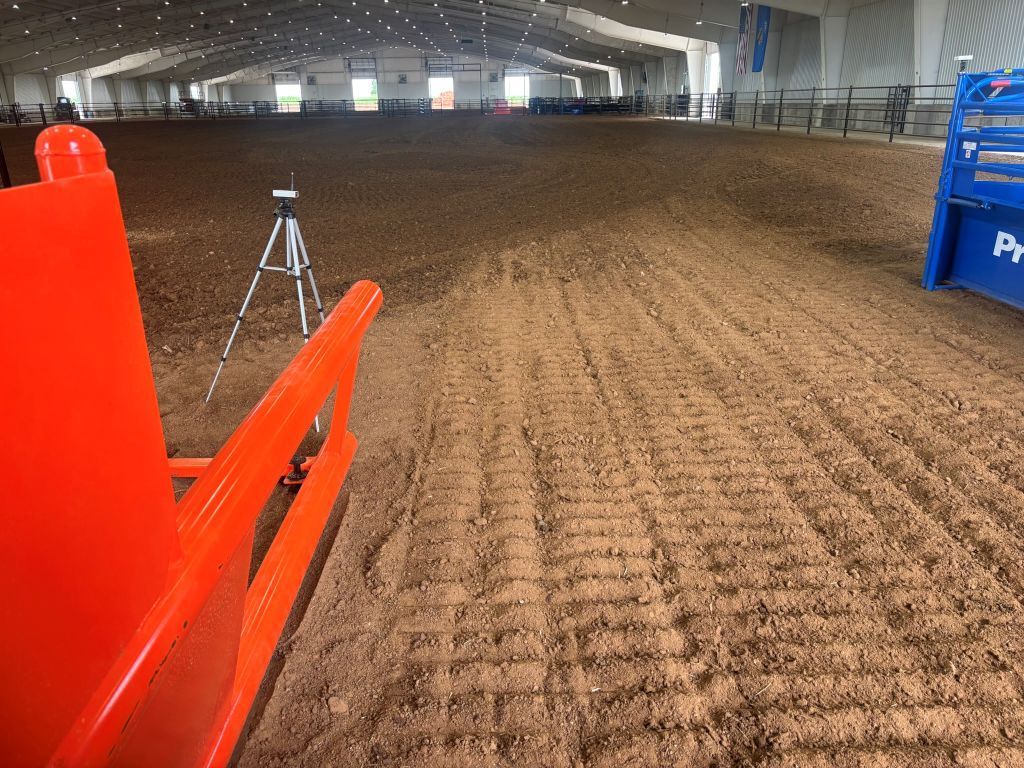 A rodeo arena with a tripod in the foreground