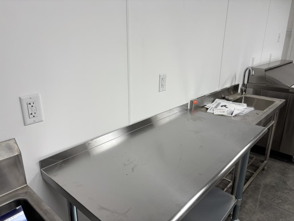 A kitchen with a stainless steel counter top and a sink.