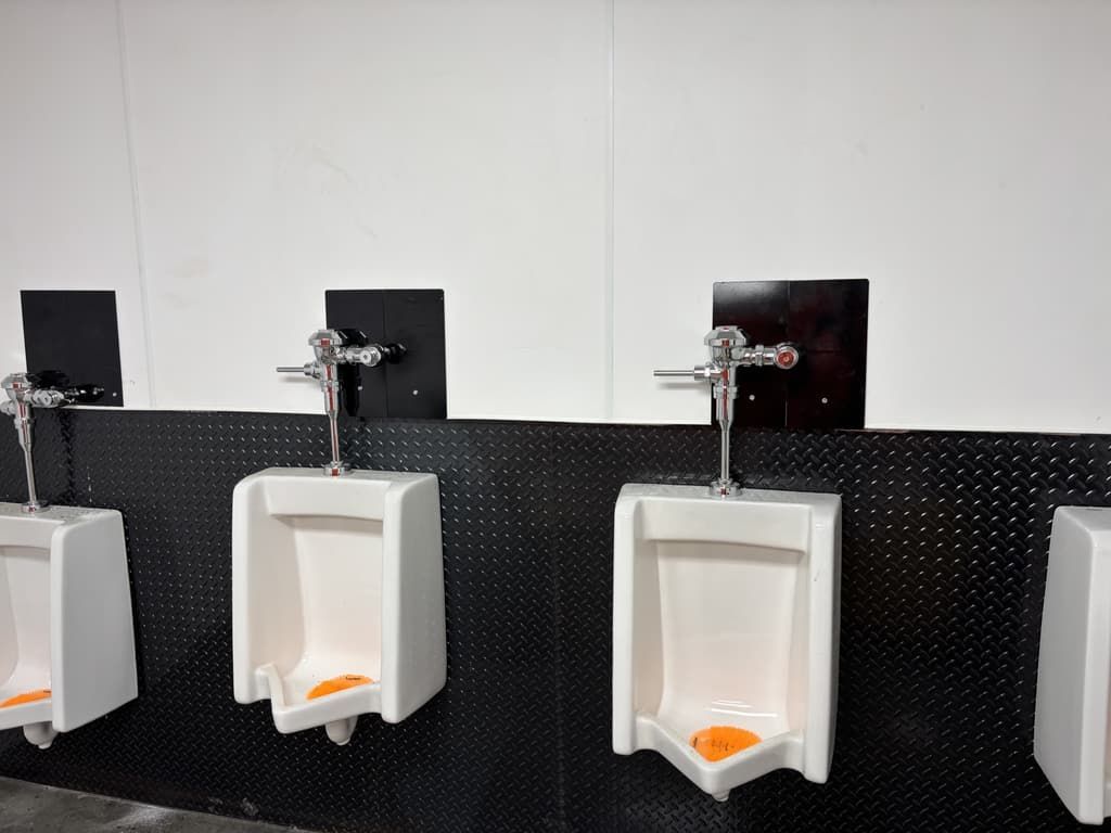 A row of urinals are lined up in a public restroom.