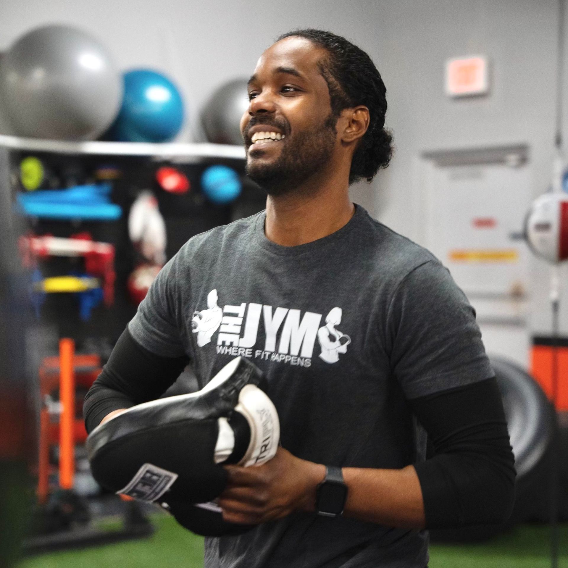 Moe Omar holding boxing glove while smiling