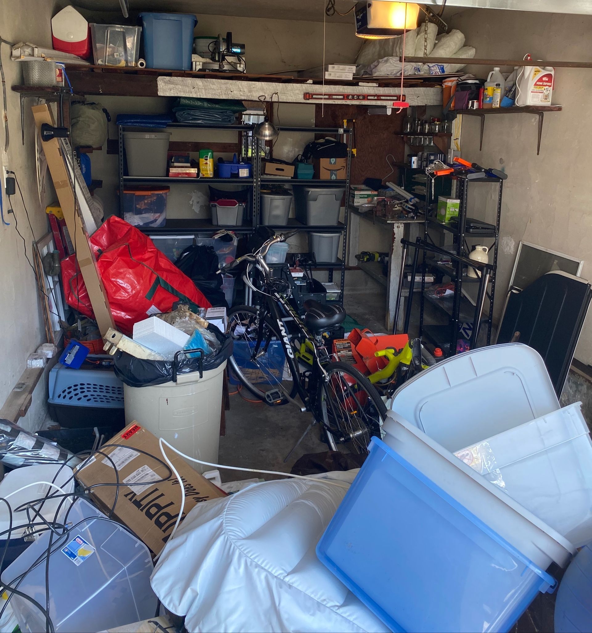 A motorcycle is parked in a messy garage filled with boxes and other items