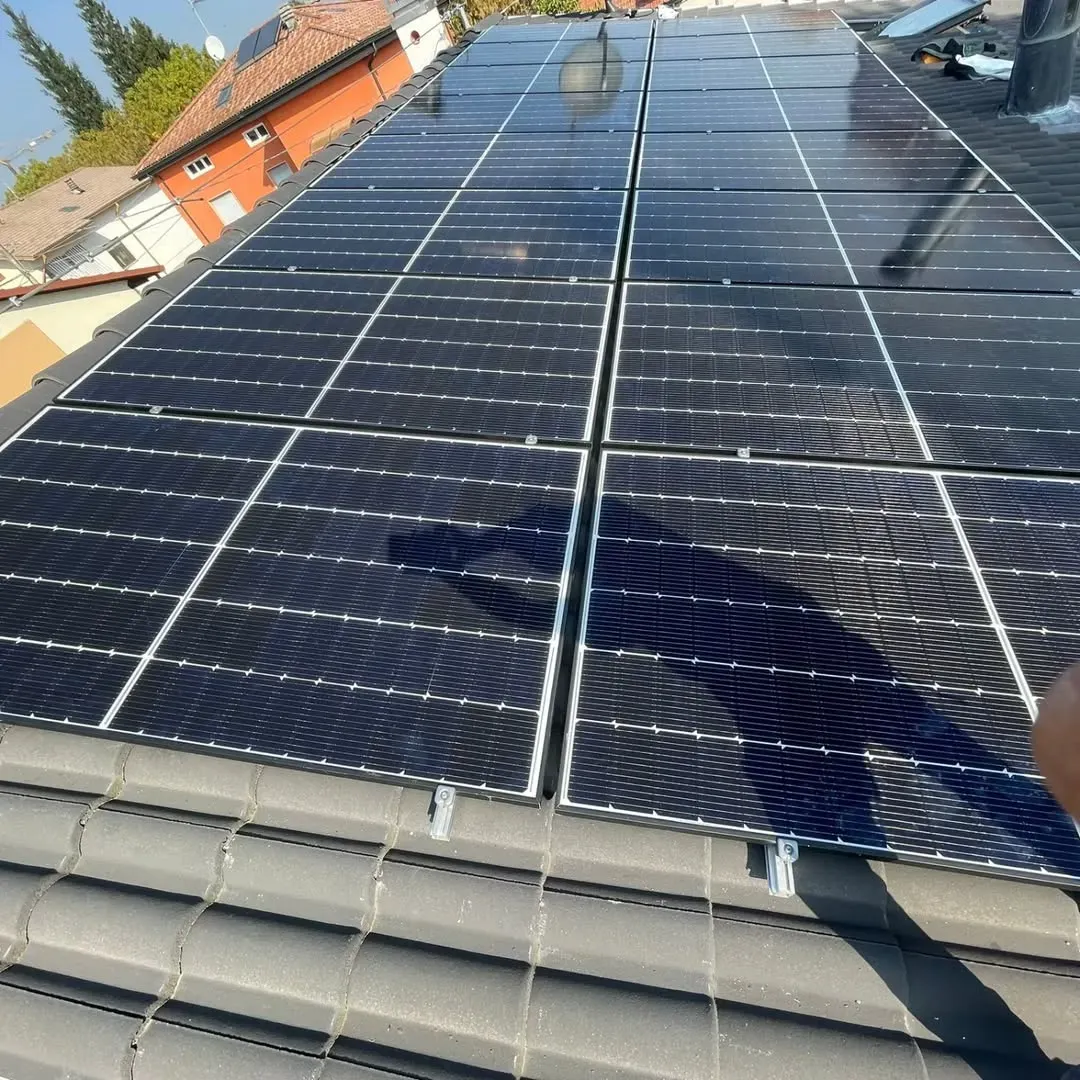 Pannelli solari installati su un tetto di tegole. I pannelli sono neri, le tegole sono grigie.