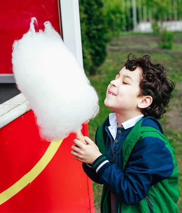 Concession Rentals — Cute Little Child Eating White Cotton Candy in In in Air in Deer Park, TX