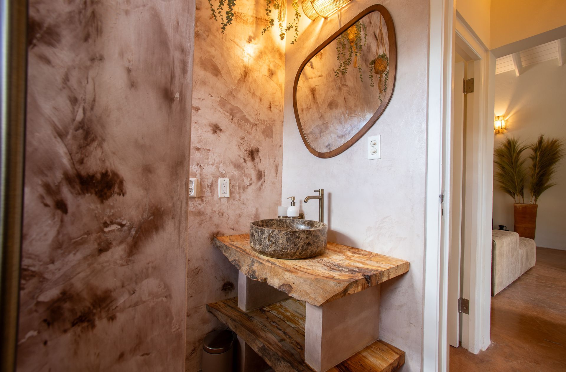 Badkamer met een rustieke uitstraling: stenen wastafel, houten badmeubel met natuurlijke randen