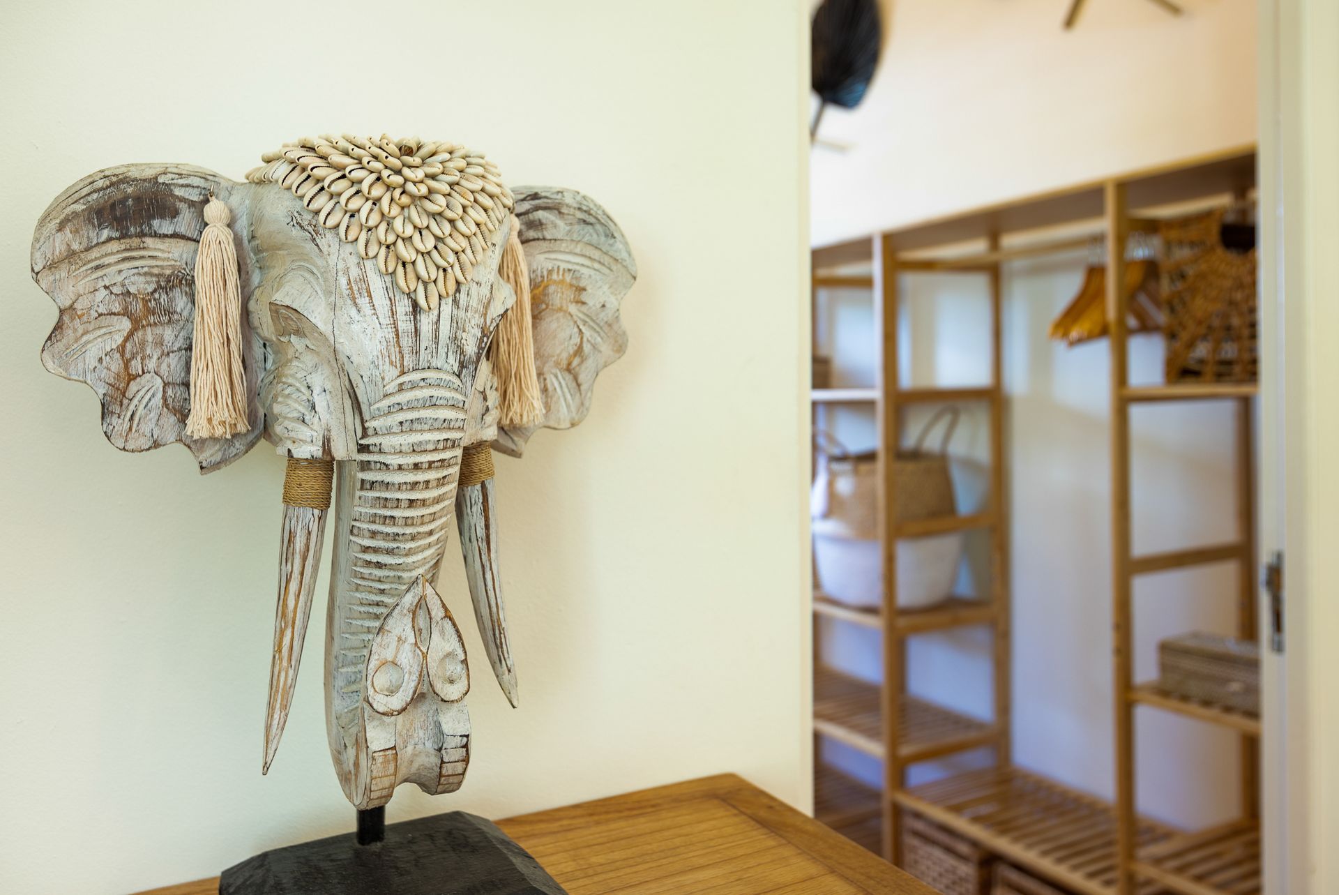 Een sculptuur van een olifantenkop op een tafel, met een kast op de achtergrond.