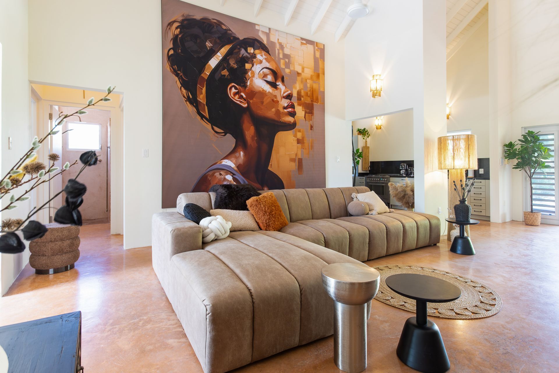 Woonkamer met een groot kunstwerk, een hoekbank en een vloerkleed.