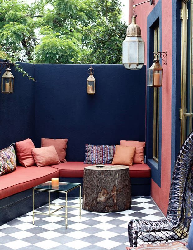 A backyard with pink chairs and cushions with black painted fence