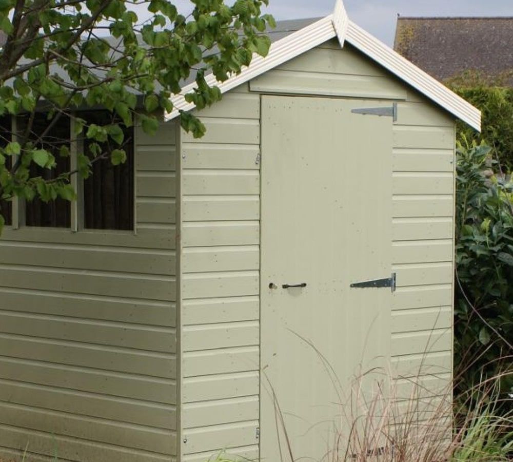 Green painted shed in a Sunderland garden in the UK. Expertly painted by Foxglove Decor.